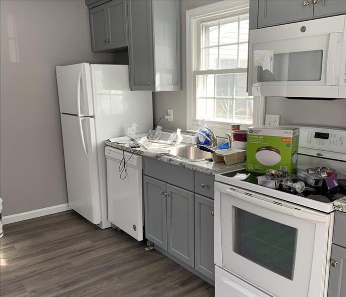 Kitchen with gray wood floors, gray walls, white appliances, gray kitchen, servpro, windsor locks