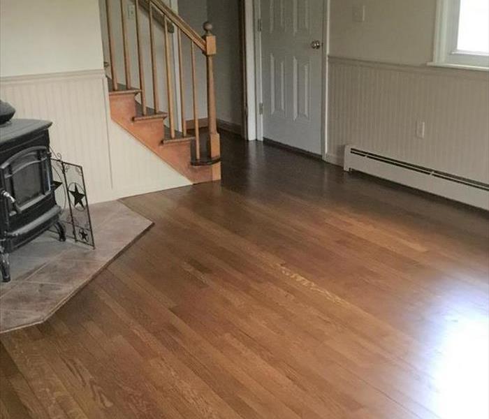 room with new shiny floors, fireplace, staircase, glare